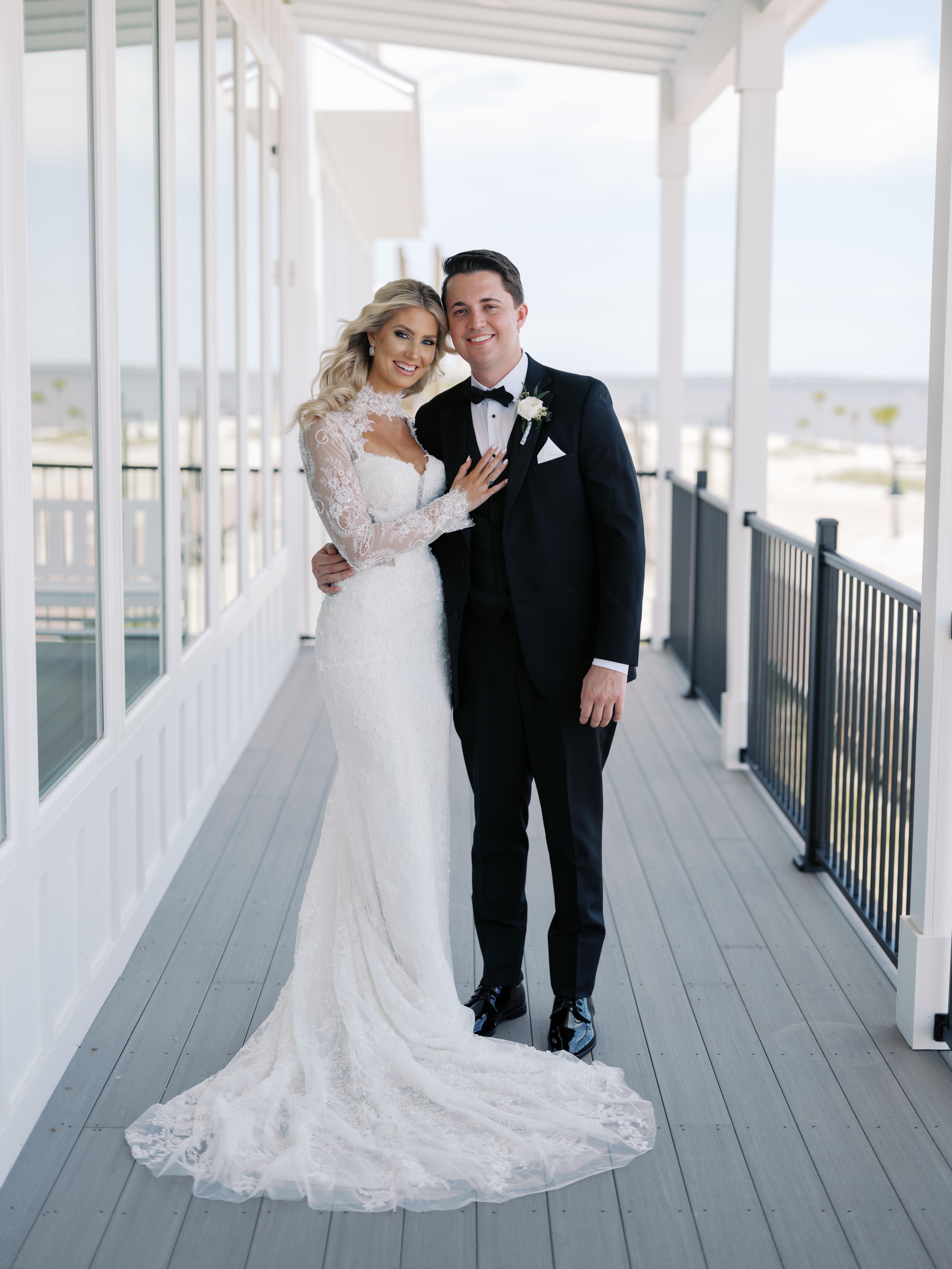 Bride and groom on the porch overlooking the beach